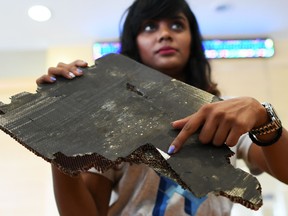 Grace Subathirai Nathan, right, daughter of Malaysian Airlines flight MH370 passenger Anne Daisy, shows a piece of debris believed to be from flight MH370 during a press conference in Putrajaya on November 30, 2018.