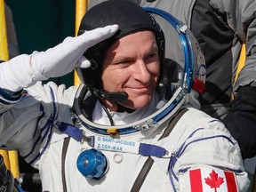 David Saint-Jacques of the Canadian Space Agency, a member of the International Space Station (ISS) expedition 58/59, gestures as he boards the Soyuz MS-11 spacecraft shortly before the launch at the Russian-leased Baikonur cosmodrome in Kazakhstan on December 3, 2018.