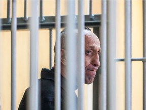 Mikhail Popkov stands inside a defendants' cage during a court hearing in Irkutsk on December 10, 2018. - A Siberian policeman who raped and killed women after offering them late-night rides was found guilty of dozens more murders on December 10, 2018, making him Russia's most prolific serial killer of recent times. A court in the city of Irkutsk found Mikhail Popkov guilty of 56 murders between 1992 and 2007, sentencing him to a second life term. He was already in prison after being convicted of killing 22 women in 2015.