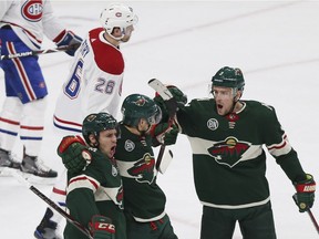 Minnesota Wild's Nino Niederreiter of Switzerland, middle, celebrates with teammates Zach Parise, left, and Charlie Coyle, right, after Niederreiter scored a goal against the Montreal Canadiens in the first period of an NHL hockey game, Tuesday, Dec. 11, 2018, in St. Paul, Minn.