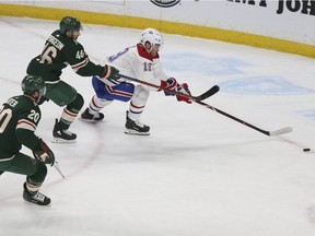 Minnesota Wild's Eric Fehr and Montreal Canadiens' Phillip Danault look toward a loose puck in the second period of an NHL hockey game Tuesday, Dec. 11, 2018, in St. Paul, Minn.