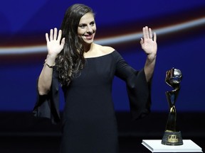 United States' Carli Lloyd waves as she stands by the World Cup trophy, during the women's soccer World Cup France 2019 draw, in Boulogne-Billancourt, outside Paris, Saturday, Dec. 8, 2018.