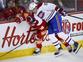 Montreal Canadiens' Noah Juulsen, right, checks Calgary Flames' Elias Lindholm, of Sweden, during NHL hockey action in Calgary on Nov. 15, 2018.