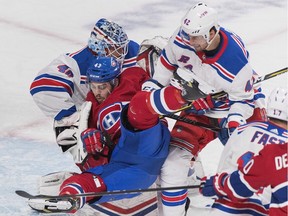 Canadiens' Michael Chaput, centre, is sandwiched between New York Rangers' Brendan Smith, right, and goaltender Alexandar Georgiev in Montreal on Saturday, Dec. 1, 2018.