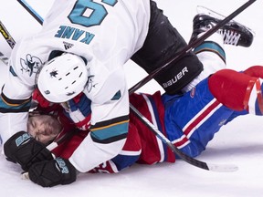 Canadiens' Andrew Shaw is overpowered by San Jose Sharks' Evander Kane in Montreal on Sunday, Dec. 2, 2018.