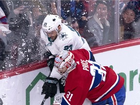 Canadiens goaltender Carey Price and the San Jose Sharks' Barclay Goodrow battle for the puck behind net during second period of NHL game at the Bell Centre in Montreal on Dec. 2, 2018.