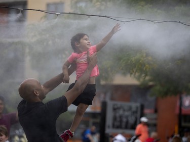 Montreal was in the middle of a heat wave. While walking along the Lachine Canal, I saw the misting station at Atwater Market and this young girl, Anokhi, who was enjoying the mist as her father, Arijit Nandi, lifted her to the peak of the stream.