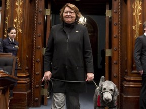 Coalition Avenir Québec MNA Claire Samson walks in the legislature with her assistance dog, Pepper, in 2015. Pepper, who helped to warn her in case of impending seizure, died recently.