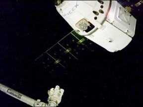 In this image taken from NASA Television, the SpaceX Dragon cargo spacecraft approaches the robotic arm for docking to the International Space Station, Saturday, Dec. 8, 2018. A communication drop-out has delayed a Christmas delivery at the International Space Station. (NASA TV via AP)