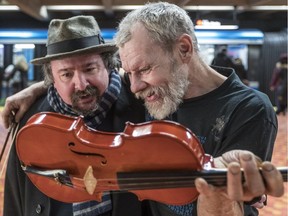 A Facebook campaign to help Mark Landry, a homeless busker who had a violin stolen twice, resulted in the donation of a violin. Rohan Quinby, left, delivered the violin to Landry at the Lionel-Groulx métro station in Montreal on Saturday Jan. 5, 2019.