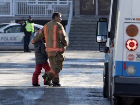 A firefighter walks a student to an STM bus during an evacuation in January 2019.
