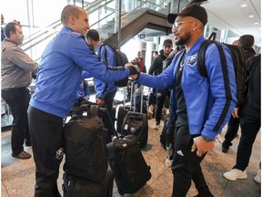 Montreal Impact goalkeeper Evan Bush, left, greets teammate Harry Novillo at Trudeau airport in Montreal on Jan. 21, 2019, as the team heads to their Florida training camp.