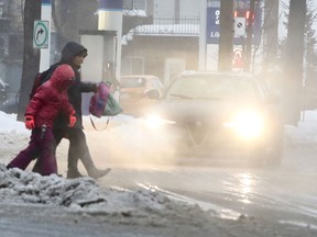 A parent and child walk home after learning school was cancelled in Montreal on Jan. 24, 2019.