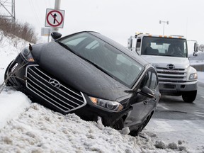 A car sits on a frozen snowbank after the driver  lost control on the Sources exit of Highway 20.
