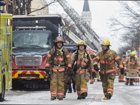 Firefighters walk on Wellington Ave. In the Verdun area of Montreal, on Saturday, January 26, 2019.  Firefighters had 2 separate fires to battle: one on 6th Ave. and another a few blocks away on Wellington Ave.