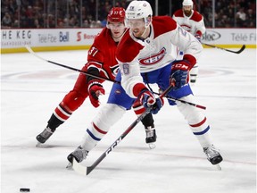 Montreal Canadiens defenceman Jeff Petry moves the puck as Carolina Hurricanes' Andrei Svechnikov loses his stick in Montreal on Dec. 13, 2018.