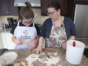 Diane Zalusky and her daughter, Eve Normand, making varenyky. The dough is formed into a large round and left to rest. Then each round is quartered, and each quarter rolled into a log shape that is in turn cut into coins and rolled into rustic rounds that are filled. (Allen McInnis / MONTREAL GAZETTE)
