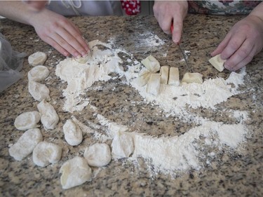 Diane Zalusky and her daughter, Eve Normand preparing varenyky. Here the dough is being cut from a log shape into smaller rounds that will be rolled out and filled. (Allen McInnis / MONTREAL GAZETTE)