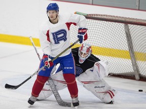Laval Rocket goalie Michael McNiven pokes his head around Laval Rocket centre Byron Froese during a team practice in Montreal on Nov. 6, 2018.