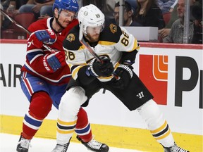 Canadiens' Max Domi tries to get past Boston Bruins' Kevan Miller in Montreal on Nov. 24, 2018.