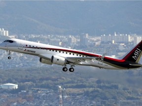 A Mitsubishi Regional Jet (MRJ) is seen flying over the city of Komaki in the Aichi prefecture, central Japan on Nov. 11, 2015 for its maiden test flight.