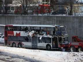 The OC Transpo bus involved in Friday's crash at Westboro Station in Ottawa was towed from the scene, revealing extensive damage, on Jan. 12, 2019.