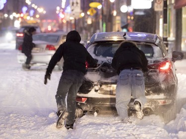 People push a car out of a snow bank during the first big snowstorm of 2019 in Montreal, Jan. 20.