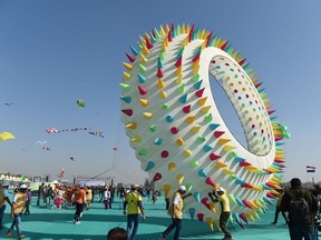 People fly a kite as they participate on the International Kite Festival in Ahmedabad on January 6, 2019.