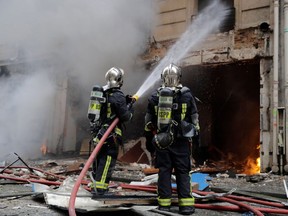 Firefighters extinguish a fire after the explosion of a bakery on the corner of the streets Saint-Cecile and Rue de Trevise in central Paris on January 12, 2019. - A large explosion badly damaged a bakery in central Paris on January 12, injuring several people and smashing windows in surrounding buildings, police and AFP journalists at the scene said. A fire broke out after the blast at around 9am (0800 GMT) in the busy 9th district of the city, which police suspect may have been caused by a gas leak.