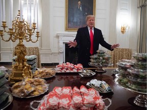 TOPSHOT - US President Donald Trump speaks alongside fast food he purchased for a ceremony honoring the 2018 College Football Playoff National Champion Clemson Tigers in the State Dining Room of the White House in Washington, DC, January 14, 2019. - Trump says the White House chefs are furloughed due to the partial government shutdown.