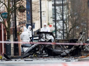 Police forensic officers inspect the aftermath of a suspected car bomb explosion in Derry, Northern Ireland, on January 20, 2019. - A suspected car bomb exploded in the Northern Irish city of Derry (Londonderry) on January 19, police said, with leading politicians alleging the blast was terror-related.