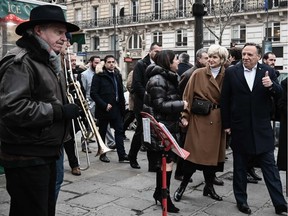 Quebec Prime Minister Francois Legault (3rd R), his wife Isabelle Brais (C) and Quebecs Minister of International Relations Nadine Girault (2nd R) walk past musicians in a street of Saint Germain des Pres, in Paris, on January 20, 2019.
