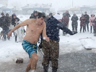 Revellers brave stormy conditions as they participate in the annual New Year's polar bear dip in Charlottetown harbour on Tuesday, Jan. 1, 2019.