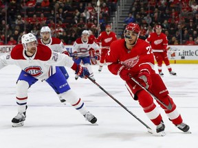 Wings centre Andreas Athanasiou keeps his eyes on the puck as Canadiens defenceman Jeff Petry keeps him to the outside Tuesday night in Detroit.