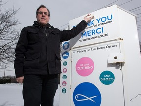 Richard Pommainville, executive director of the Saint Vincent de Paul Society, with one of their donation bins. Piommainville says it would be difficult to get into one of the boxes.