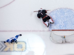 Canada goalie Michael DiPietro lies on the ice after allowing the winning goal as Finland's Aleksi Heponiemi celebrates.