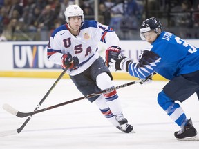 United States' Ryan Poehling (11) fights for control of the puck with Finland's Toni Utunen (3) during second period IIHF world junior hockey action in Victoria, Monday, Dec. 31, 2018.