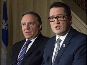 New Environment Minister Benoit Charette, right, with François Legault, said he doesn't see any contradiction between his party's promise to build a bridge or tunnel for cars between Quebec City and Lévis and reducing Quebec's greenhouse gas emissions.