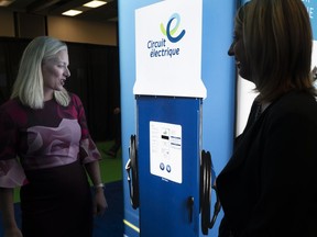 Federal environment minister Catherine McKenna and France Lampron of Hydro-Québec look at an image of a fast charger as they announce an investment to build 100 chargers for electric vehicles across Quebec during a news conference in Montreal on Wednesday, January 23, 2019.