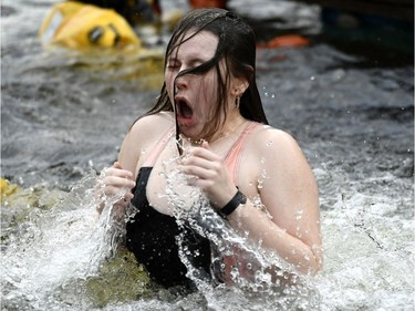 A woman reacts as she emerges from the water during the Perth Polar Bear Plunge in Perth, Ont. on New Year's Day, Tuesday, Jan. 1, 2019. The water temperature was around one degree Celcius, with air temperature at minus four degrees.