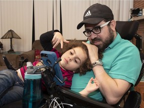 Aymen Derbali enjoys some quality time with his daughter Maryem in their home, in Quebec City, Thursday, Jan. 24, 2019. Two years ago, on Jan. 29, 2017, a gunman's rampage at the Quebec Mosque left Derbali paralyzed.