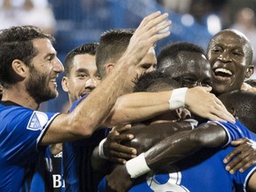 Montreal Impact players celebrate a goal by teammate Bacary Sagna against the New York Red Bulls during first half MLS soccer action in Montreal on Sept. 1, 2018.