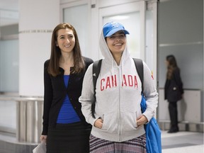 Saudi teenager Rahaf Mohammed Alqunun, right, stands with Saba Abbas from COSTI Immigrant Services, as she arrives at Toronto Pearson International airport, on Saturday, January 12, 2019.