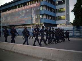 Congolese riot police patrols outside the Independent electoral commission building at dusk in Kinshasa, Thursday Jan. 10, 2019, the day Felix Tshisekedi has been declared the winner of the presidential elections.