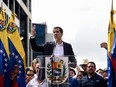 Venezuela's National Assembly head Juan Guaido waves to the crowd during a mass opposition rally against leader Nicolas Maduro in which he declared himself the country's "acting president" on the anniversary of a 1958 uprising that overthrew military dictatorship, in Caracas on January 23, 2019.