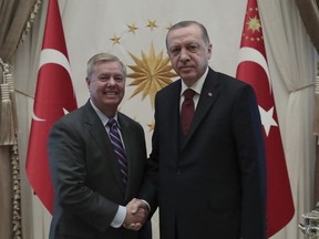 Turkey's President Recep Tayyip Erdogan, right, and U.S. Republican Senator Lindsey Graham shake hands before a meeting in Ankara, Turkey, Friday, Jan. 18, 2019. Erdogan and Graham has discussed the situation in Syria as the United States prepares to withdraw troops.(Presidential Press Service via AP, Pool)