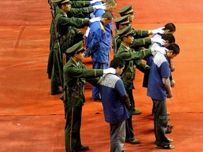 Iranian journalists film a row of accused drug smugglers at a police station in Iran, 03 January 2006.