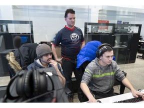 Patrick Rheaume-Espinoza, operations director for the Montreal Esports Academy, oversees head trainer Antonin Tran, left, working with student Eliyakim Bezeau in Montreal on Thursday, January 31, 2019.