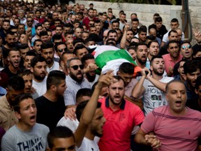 Palestinians carry the body of Aisha Mohammed Rabi during her funeral in the West Bank village of Biddya on Oct. 13.