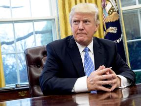 U.S. President Donald Trump prepares to sign several executive orders in the Oval Office of the White House, Jan. 23, 2017.